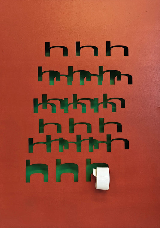 Brown wall with black cut-out letters and a white light switch.
