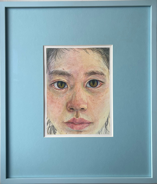 Framed artwork of a young person's face with a blue border