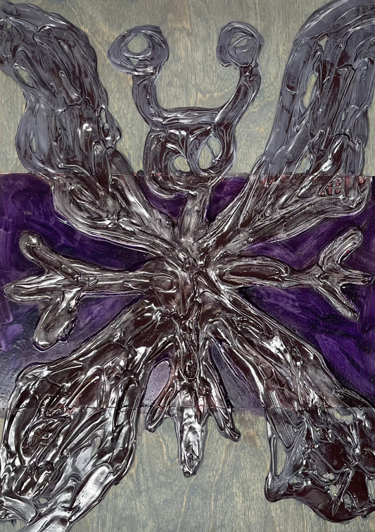 Two abstract artworks on canvas with metallic butterfly design on a wooden surface.