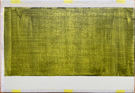 Rectangular piece of green fabric on a wooden board with yellow tape