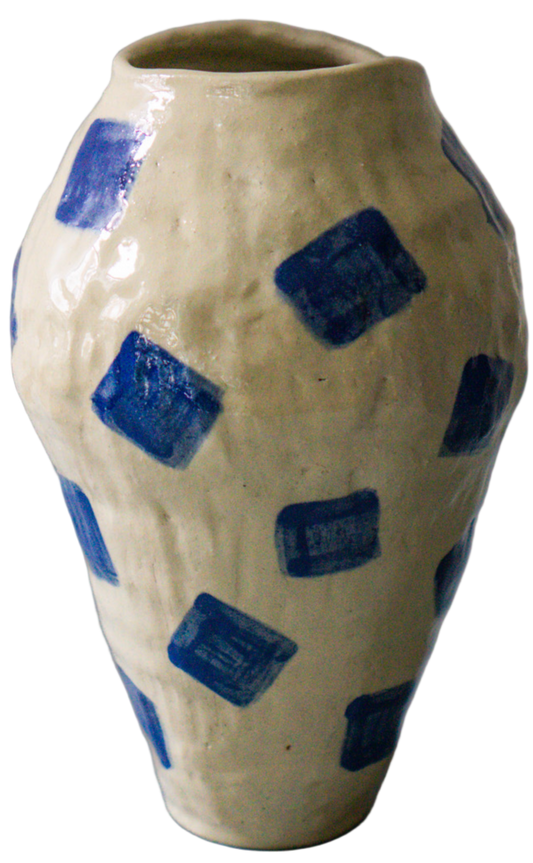Ceramic vase with blue square patterns on a gray surface and light gray background