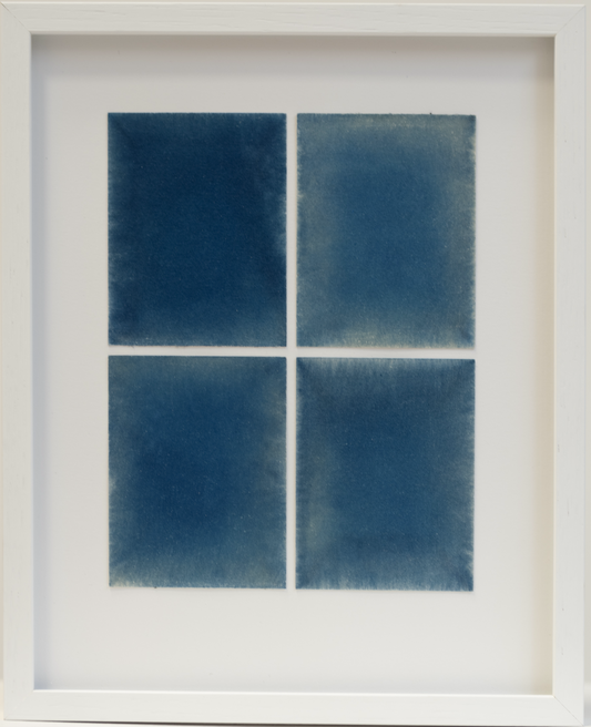 Framed artwork with blue abstract design on a white wall