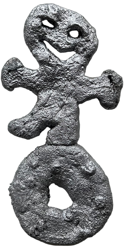 Metallic gingerbread man decoration on a textured surface