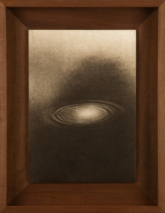 Framed artwork of a circular design on a textured surface